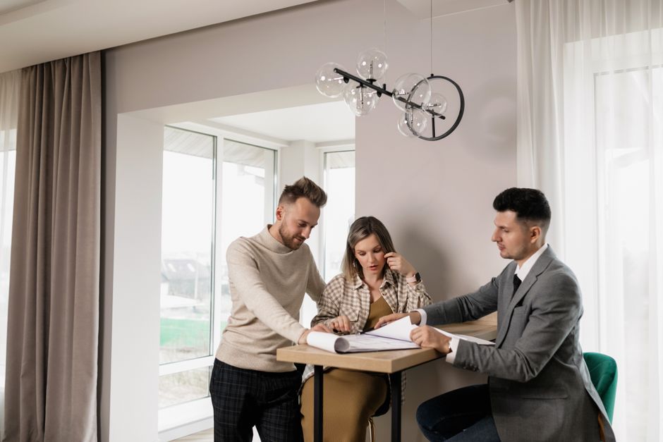 A professional and clean shot of hands signing legal documents on a modern wooden desk in a bright, airy room, illustrating the secure legal process of buying property.